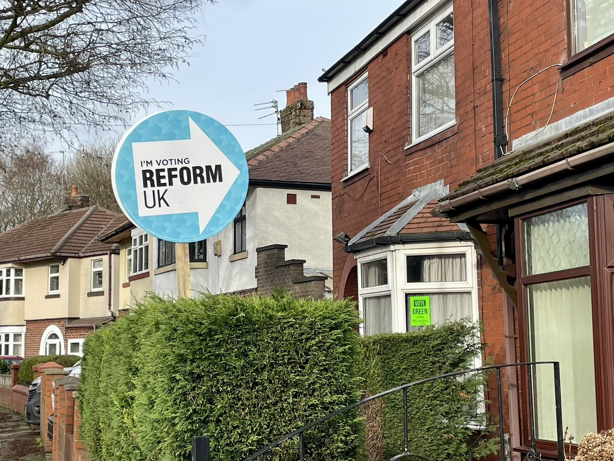Reform UK campaign posters displayed on a residential street